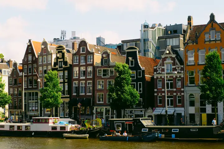Dutch gabled canal houses and houseboats along the water in Amsterdam, the Netherlands